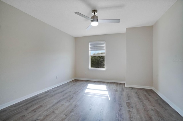 unfurnished room featuring baseboards, ceiling fan, and wood finished floors