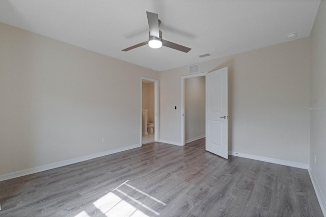 unfurnished bedroom featuring baseboards, visible vents, ceiling fan, and wood finished floors