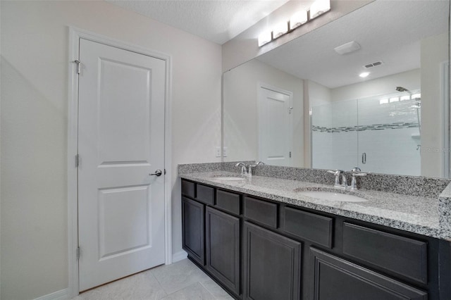 bathroom with double vanity, a sink, visible vents, and a shower stall