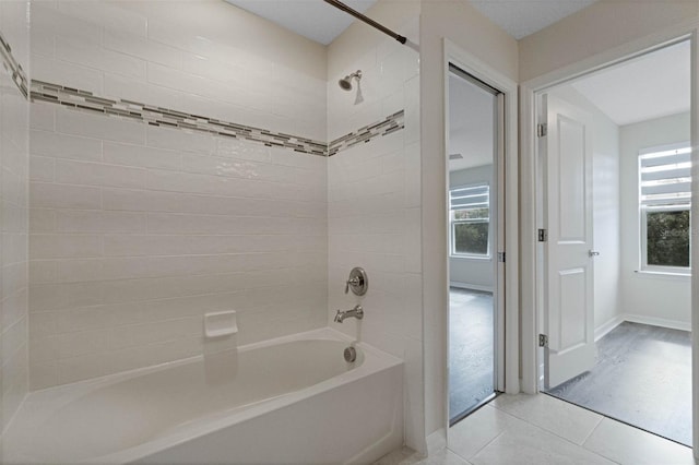 full bath featuring baseboards, shower / bath combination, tile patterned floors, and plenty of natural light