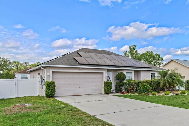 ranch-style house with a garage, stucco siding, solar panels, and a gate