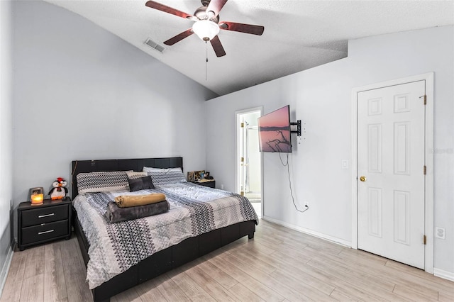 bedroom with baseboards, vaulted ceiling, light wood-style flooring, a ceiling fan, and visible vents