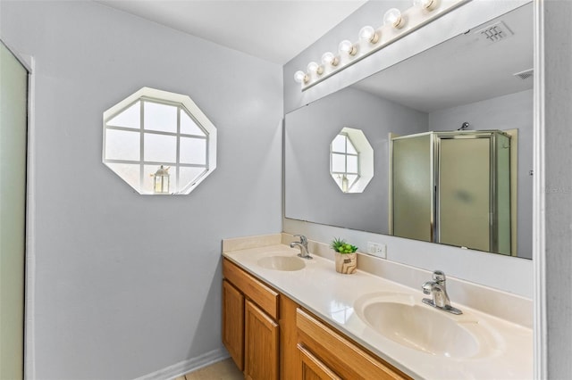 full bathroom with a stall shower, double vanity, a sink, and visible vents