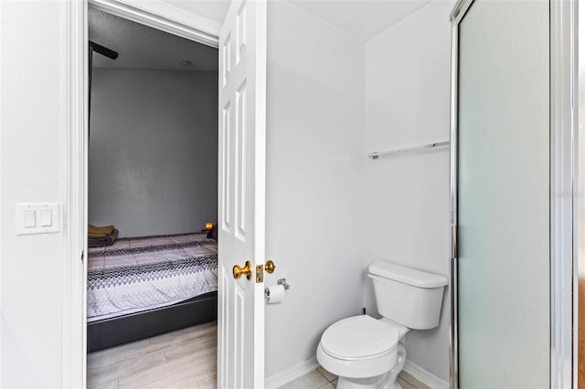 bathroom featuring baseboards, toilet, and wood finished floors