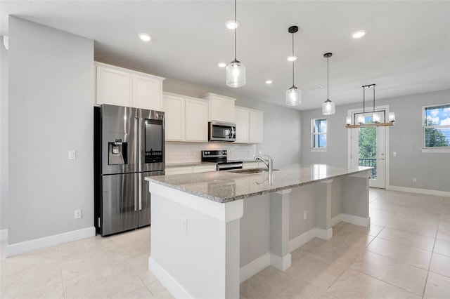 7772 Sweet Star Ave, Orlando, FL 32836 - kitchen with tasteful backsplash, a sink, appliances with stainless steel finishes, an island with sink, and white cabinetry