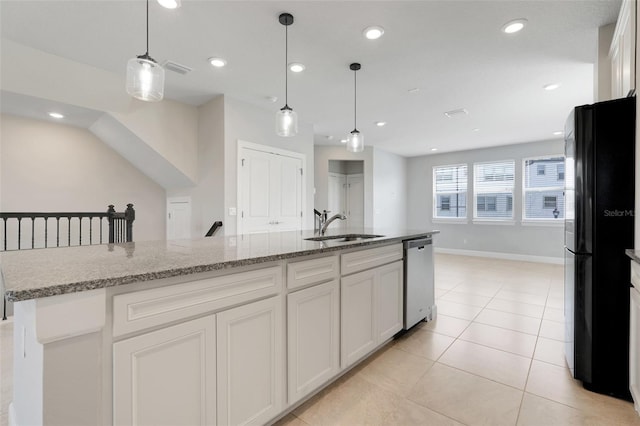 7772 Sweet Star Ave, Orlando, FL 32836 - kitchen featuring light tile patterned floors, a sink, freestanding refrigerator, white cabinetry, and stainless steel dishwasher