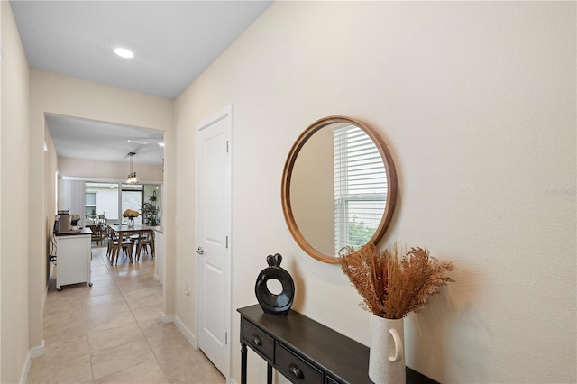 hallway featuring light tile patterned flooring, baseboards, and recessed lighting