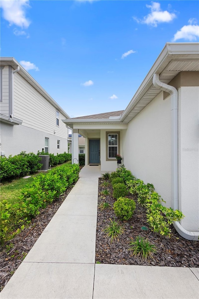 doorway to property featuring central air condition unit and stucco siding