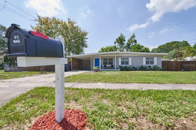 1405 Smith Dr N, Titusville, FL 32780 - view of front of house with driveway, stucco siding, fence, a front lawn, and a carport