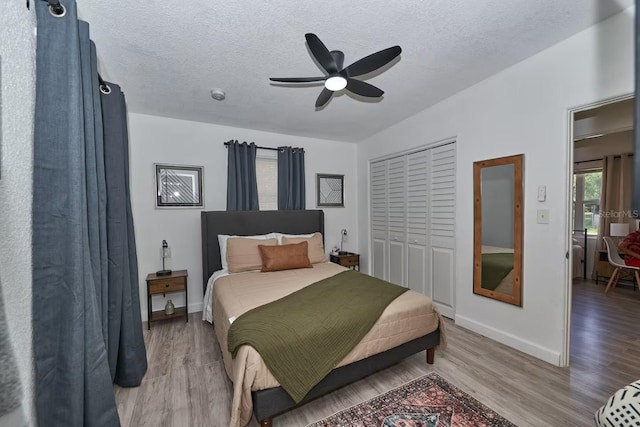 1405 Smith Dr N, Titusville, FL 32780 - bedroom featuring a closet, a textured ceiling, baseboards, a ceiling fan, and light wood-style floors
