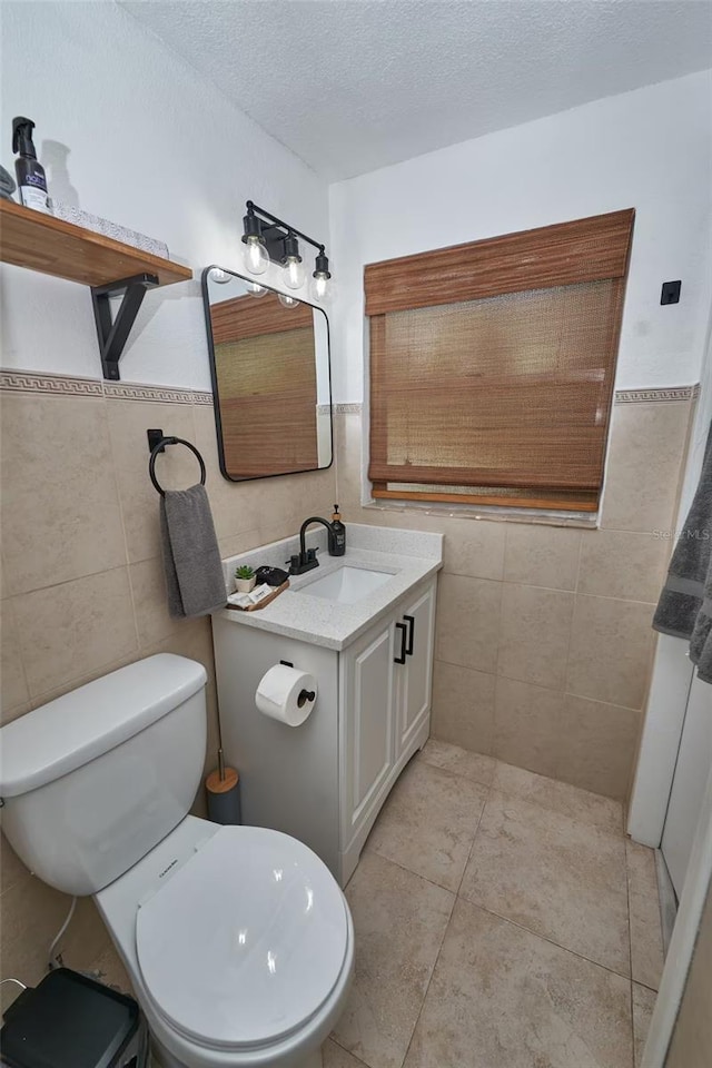 1405 Smith Dr N, Titusville, FL 32780 - half bath featuring tile patterned flooring, vanity, tile walls, toilet, and a textured ceiling