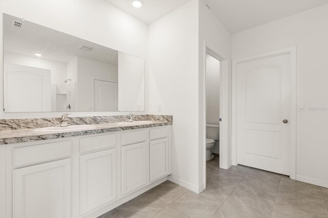 715 Chinoy Rd, Davenport, FL 33837 - full bathroom with toilet, double vanity, a sink, and baseboards