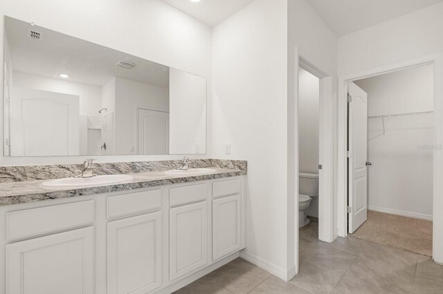 715 Chinoy Rd, Davenport, FL 33837 - full bathroom with toilet, double vanity, a sink, and a spacious closet