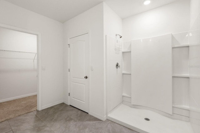 715 Chinoy Rd, Davenport, FL 33837 - bathroom with walk in shower, baseboards, a walk in closet, recessed lighting, and tile patterned flooring