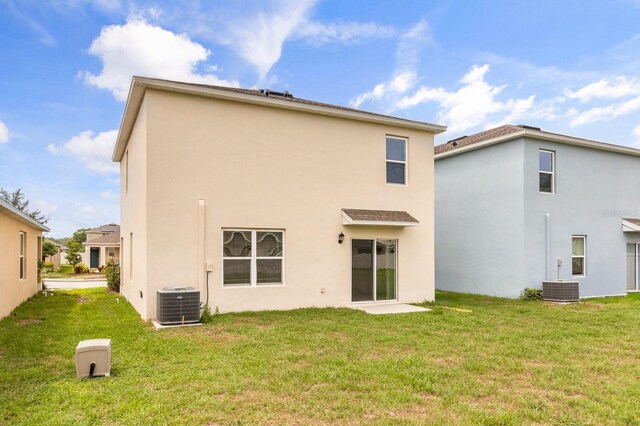 715 Chinoy Rd, Davenport, FL 33837 - rear view of property featuring central AC unit, a yard, and stucco siding