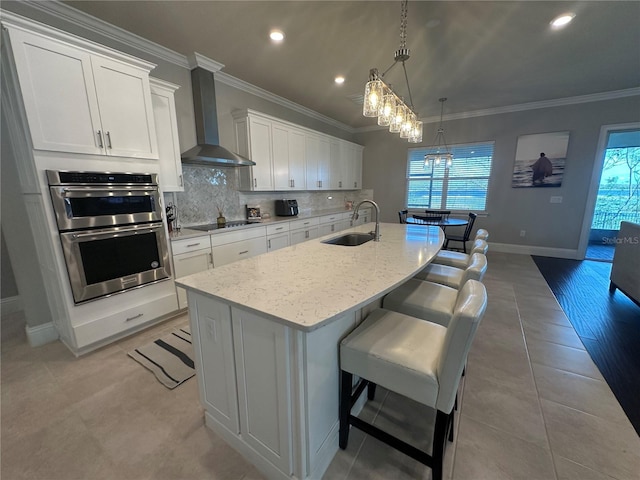 3399 Buoy Cir, Winter Garden, FL 34787 - kitchen with crown molding, wall chimney exhaust hood, a sink, black electric stovetop, and double oven