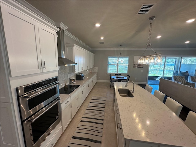 3399 Buoy Cir, Winter Garden, FL 34787 - kitchen featuring visible vents, stainless steel double oven, a sink, black electric stovetop, and a large island