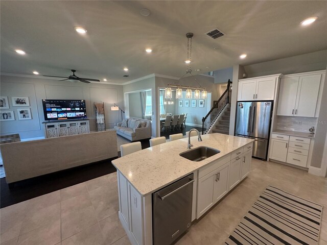 3399 Buoy Cir, Winter Garden, FL 34787 - kitchen featuring white cabinets, a kitchen island with sink, stainless steel appliances, tasteful backsplash, and a sink