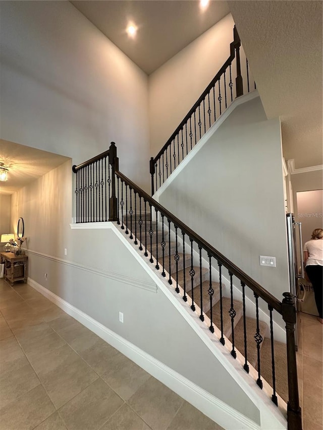3399 Buoy Cir, Winter Garden, FL 34787 - stairway featuring baseboards, a towering ceiling, and tile patterned floors