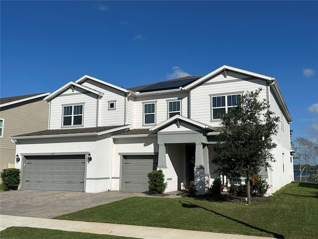 3399 Buoy Cir, Winter Garden, FL 34787 - view of front of home featuring stucco siding, an attached garage, driveway, a front yard, and roof mounted solar panels