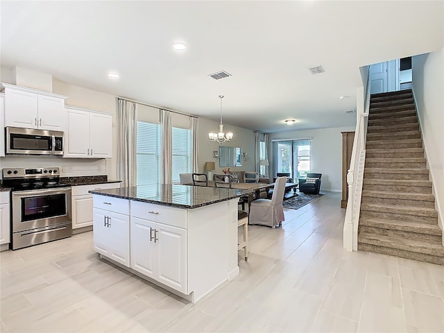 9432 Komika Ln, Winter Garden, FL 34787 - kitchen featuring visible vents, a chandelier, a kitchen bar, a kitchen island, and appliances with stainless steel finishes