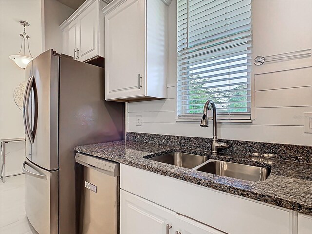 9432 Komika Ln, Winter Garden, FL 34787 - kitchen featuring white cabinetry, a sink, dark stone countertops, and stainless steel dishwasher