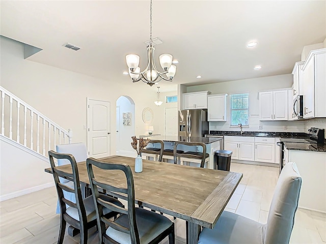 9432 Komika Ln, Winter Garden, FL 34787 - dining room featuring a notable chandelier, recessed lighting, baseboards, visible vents, and arched walkways