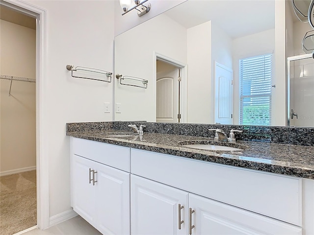 9432 Komika Ln, Winter Garden, FL 34787 - bathroom with a sink, double vanity, a walk in closet, and baseboards