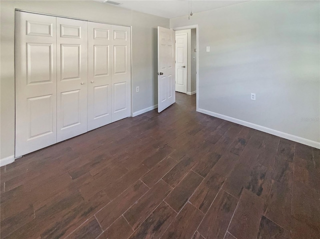 701 71st Ave N, Saint Petersburg, FL 33702 - unfurnished bedroom with baseboards, dark wood finished floors, and a closet