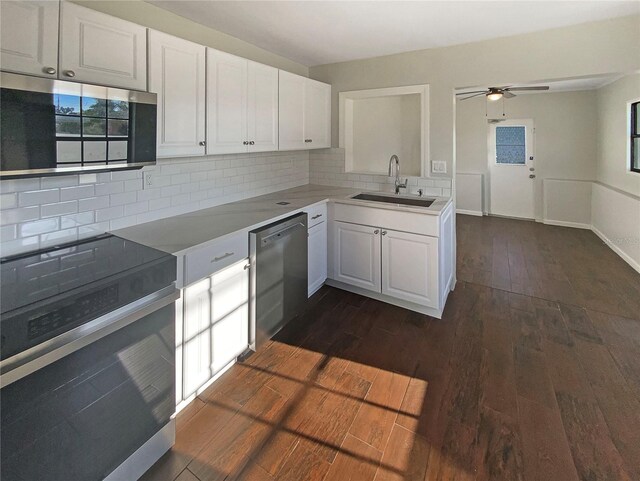 701 71st Ave N, Saint Petersburg, FL 33702 - kitchen featuring stainless steel appliances, a sink, a ceiling fan, dark wood finished floors, and white cabinetry