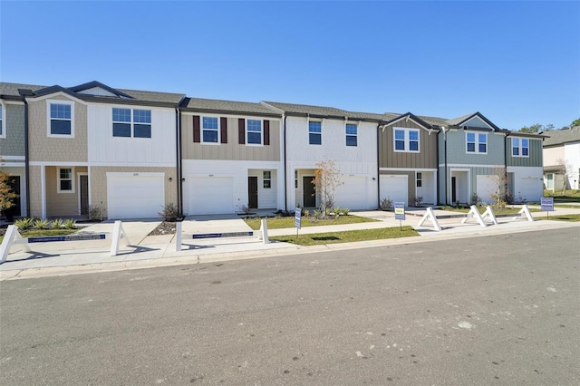 multi unit property featuring a residential view, driveway, and an attached garage