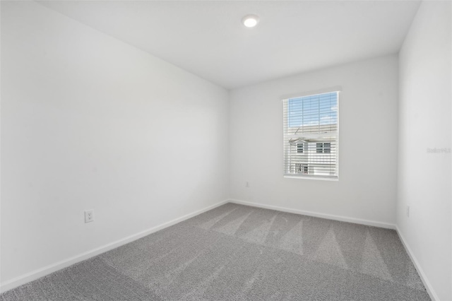 carpeted spare room with baseboards