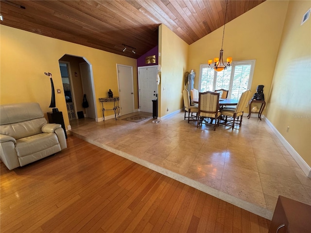 913 Red Fox Rd, Altamonte Springs, FL 32714 - dining room with arched walkways, a chandelier, wooden ceiling, light wood-style floors, and baseboards