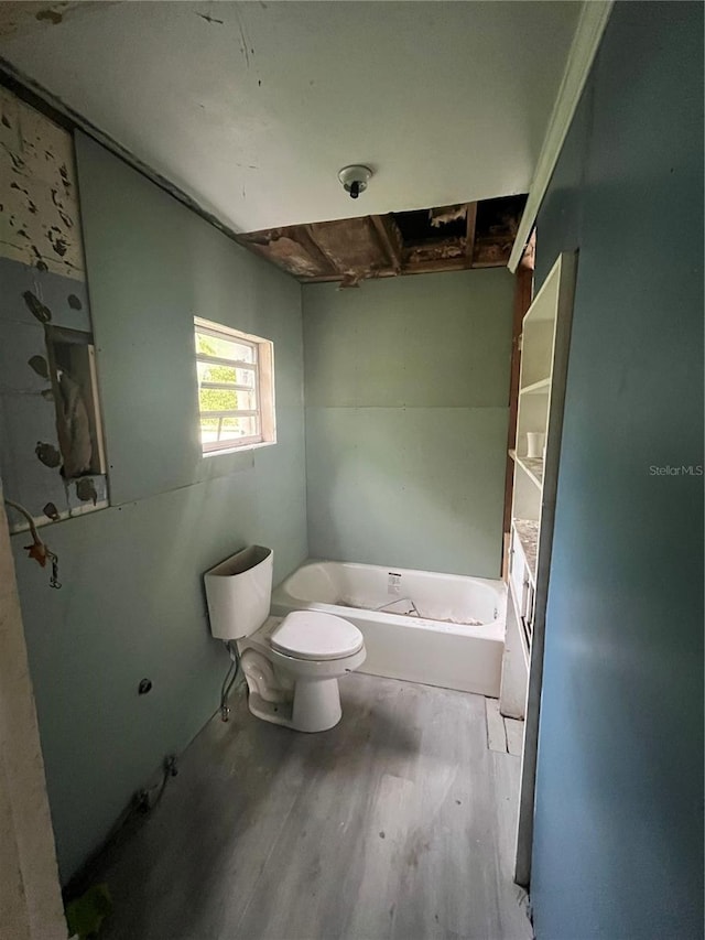 1905 S Westmoreland Dr, Orlando, FL 32805 - bathroom featuring wood finished floors, toilet, and a bath