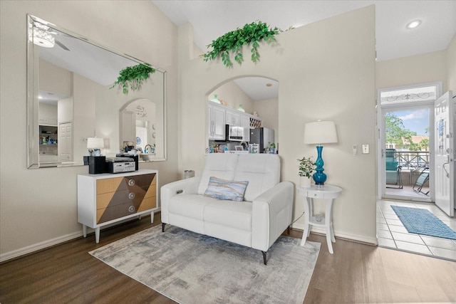 2808 Osprey Cove Pl Unit 201, Kissimmee, FL 34746 - living area with wood finished floors, arched walkways, baseboards, and high vaulted ceiling