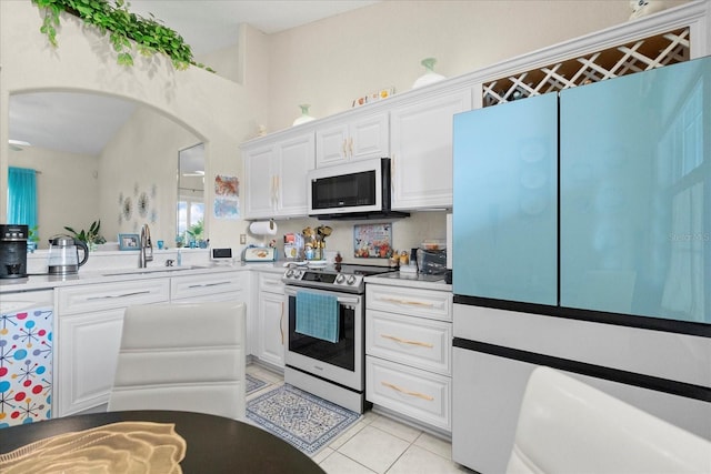 2808 Osprey Cove Pl Unit 201, Kissimmee, FL 34746 - kitchen with white microwave, electric range, fridge, arched walkways, and white cabinetry