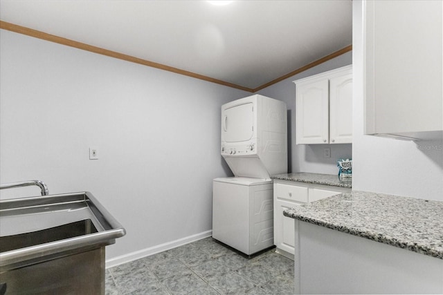 10809 Cedar Cove Dr, Thonotosassa, FL 33592 - clothes washing area with baseboards, stacked washer and dryer, ornamental molding, and cabinet space