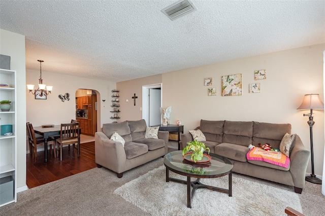 4520 Browning Ave, Titusville, FL 32780 - carpeted living room with arched walkways, a notable chandelier, visible vents, and a textured ceiling