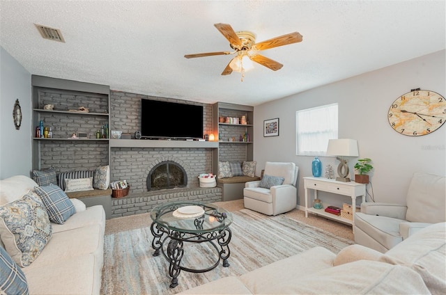 4520 Browning Ave, Titusville, FL 32780 - living room featuring ceiling fan, a fireplace, a textured ceiling, visible vents, and built in shelves