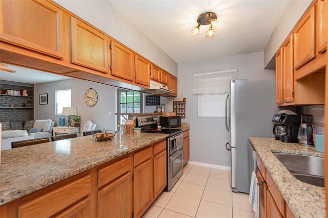 4520 Browning Ave, Titusville, FL 32780 - kitchen with light tile patterned floors, a sink, under cabinet range hood, black microwave, and range with two ovens