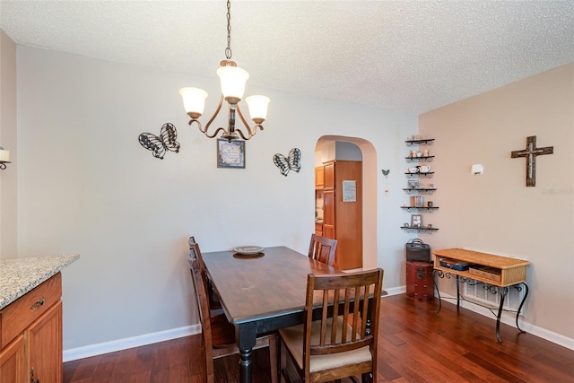 4520 Browning Ave, Titusville, FL 32780 - dining space featuring baseboards, an inviting chandelier, a textured ceiling, dark wood-type flooring, and arched walkways