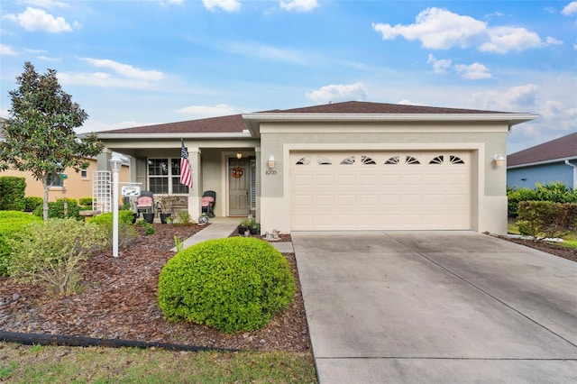 single story home with a porch, concrete driveway, stucco siding, and an attached garage