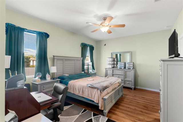bedroom with baseboards, ceiling fan, and wood finished floors