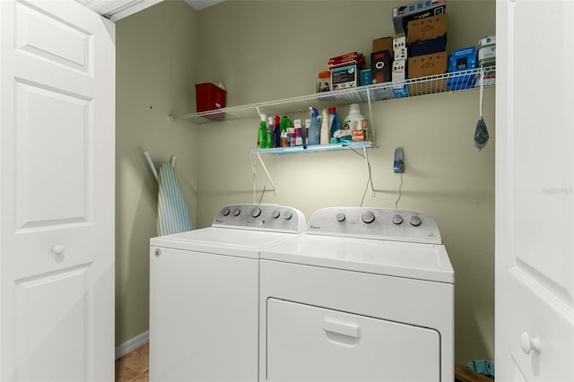 laundry area with baseboards, independent washer and dryer, laundry area, and light tile patterned flooring
