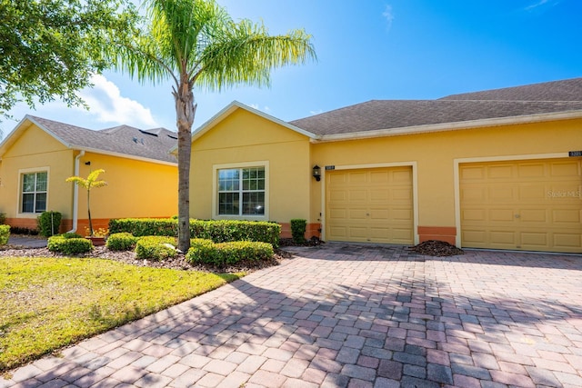 3205 Sonesta Ct Unit F, Clermont, FL 34711 - single story home featuring stucco siding, an attached garage, roof with shingles, and decorative driveway