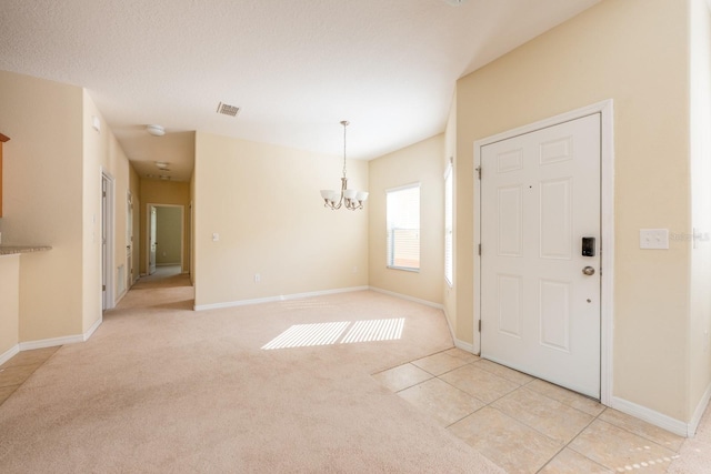 3205 Sonesta Ct Unit F, Clermont, FL 34711 - foyer entrance featuring an inviting chandelier, light carpet, baseboards, and visible vents