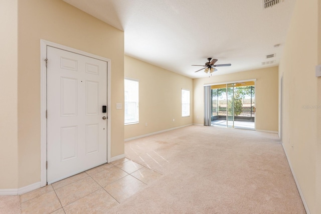 3205 Sonesta Ct Unit F, Clermont, FL 34711 - entryway with visible vents, baseboards, a ceiling fan, light tile patterned floors, and light colored carpet