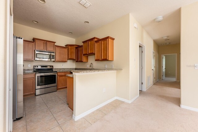 3205 Sonesta Ct Unit F, Clermont, FL 34711 - kitchen with stainless steel appliances, brown cabinets, and visible vents