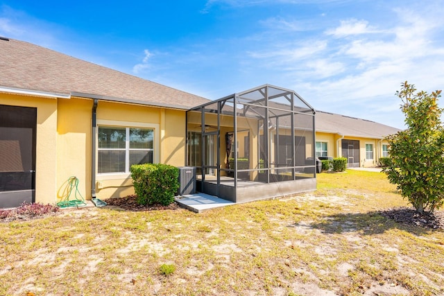 3205 Sonesta Ct Unit F, Clermont, FL 34711 - rear view of property with glass enclosure, stucco siding, and a yard