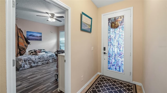 entrance foyer featuring baseboards, a ceiling fan, and wood finished floors